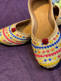 Gold Multicolor Embroidered Punjabi Jutti – Handcrafted Ethnic Footwear with Vibrant Threadwork & Pom-Pom Detailing
